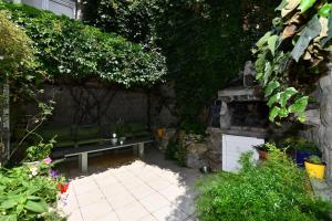 einen Garten mit einer Bank und einem Steinkamin in der Unterkunft Vila NANA in Sinj