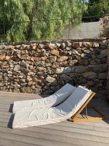 a chaise lounges on a patio next to a stone wall at CABANON in Carqueiranne