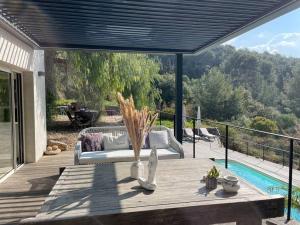 a patio with a couch and a table and a pool at CABANON in Carqueiranne