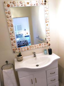 a bathroom with a sink and a mirror at Cottage in Voëlklip between mountain and sea in Hermanus