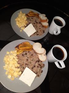 zwei Teller Essen auf einem Tisch mit zwei Tassen Kaffee in der Unterkunft Ocean view in Monteverde Costa Rica