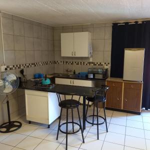 a kitchen with a table and some chairs in it at Rilli's Inn Studio in Mtunzini