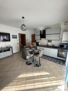eine Küche mit einem Tisch und Stühlen im Zimmer in der Unterkunft Lussuoso Bilocale con parcheggio gratuito in Rovello Porro