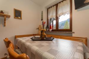 ein Zimmer mit einem Tisch und einem Fenster in der Unterkunft Ciesa Migon in Alleghe