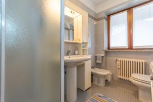ein Badezimmer mit Waschbecken und Toilette in der Unterkunft Ciesa Migon in Alleghe