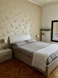Schlafzimmer mit einem Bett und einem Wandspiegel in der Unterkunft Splendido Bilocale adiacente metro M5 - Ca Granda in Mailand