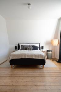 een slaapkamer met een bed en een witte muur bij FeelsLikeHome - Schöne&zentral angebundene Altbauwohnung mit Parkplatz in Bochum