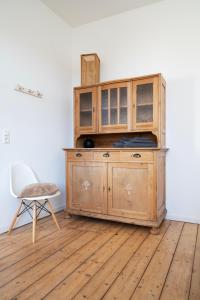 a wooden cabinet in a room with a chair at FeelsLikeHome - Schöne&zentral angebundene Altbauwohnung mit Parkplatz in Bochum