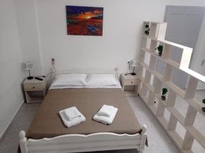 een slaapkamer met een bed met twee handdoeken erop bij Alexia's Houses in Kalamaki