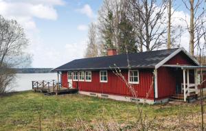 een rood huis aan de oever van een meer bij Stunning Home In Ludvika With Lake View in Ludvika