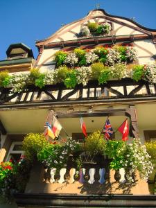 a building with lots of plants and flags on it at Hotel Restaurant Krone in Wolfach