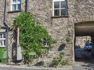 a stone building with a tree in front of it at No6, Queens square in Kirkby Lonsdale