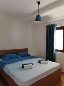 - une chambre dotée d'un grand lit avec des draps bleus et une fenêtre dans l'établissement Villa Apartments STEFAN - Ramne Ohrid, à Ohrid