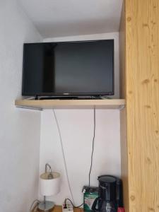 une télévision à écran plat installée au-dessus d'une étagère. dans l'établissement Studio "Le Rigaou", à Gréoux-les-Bains