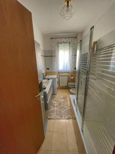 ein Bad mit einer Dusche, einem Waschbecken und einem WC in der Unterkunft Lussuoso Bilocale con parcheggio gratuito in Rovello Porro