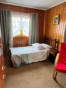 sypialnia z łóżkiem i oknem w obiekcie Hospedaje BoppHouse w mieście Coihaique