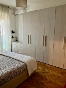 a bedroom with a bed and a dresser and cabinets at Splendido Bilocale adiacente metro M5 - Ca Granda in Milan