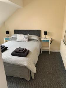 um quarto com uma cama com duas mesas e dois candeeiros em RUDGRAVE SQUARE WALLASEY em Wallasey