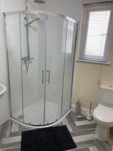 uma casa de banho com um chuveiro e um WC. em RUDGRAVE SQUARE WALLASEY em Wallasey