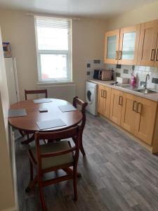 a kitchen with a table and chairs in a room at RUDGRAVE SQUARE WALLASEY in Wallasey