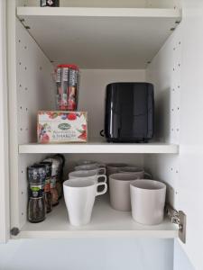 una dispensa con tazze e forno a microonde di 89 - Apartamenty Siedlce - Nowy apartament przy ul. Rakowieckiej a Siedlce