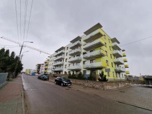 un edificio de apartamentos blanco y amarillo en el lateral de una calle en 89 - Apartamenty Siedlce - Nowy apartament przy ul. Rakowieckiej, en Siedlce