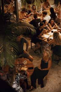 un grupo de personas sentadas en mesas en un restaurante en Somos, en Santa Teresa Beach