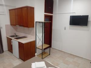 una piccola cucina con lavandino e TV di Alexia's Houses a Kalamaki Altre 39 foto