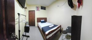 um pequeno quarto com uma cama e uma televisão em Hotel Barlovento Inn Piura em Piura