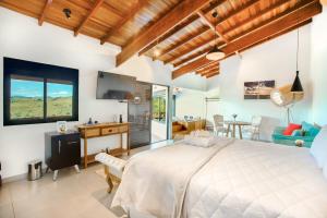 um quarto com uma cama grande e uma sala de estar em Pousada Lago dos Sonhos em Piracaia