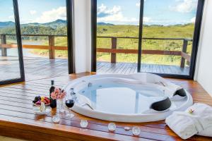 bañera con mesa de madera y vistas en Pousada Lago dos Sonhos en Piracaia