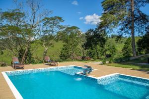 a swimming pool in the middle of a yard at Pousada Lago dos Sonhos in Piracaia