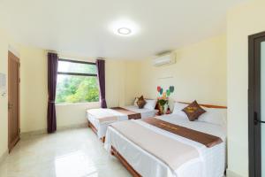 um quarto com 2 camas e uma janela em Victor Charlie Hostel 2 em Ilha de Cát Bà