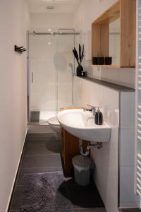 ein weißes Bad mit einem Waschbecken und einer Dusche in der Unterkunft FeelsLikeHome - Schöne&zentral angebundene Altbauwohnung mit Parkplatz in Bochum