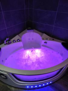 bañera púrpura con iluminación púrpura en el baño en LoveroomXspa, en Bourg-Saint-Christophe