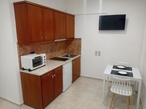 una piccola cucina con forno a microonde e lavandino di Alexia's Houses a Kalamaki