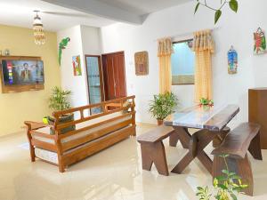 a living room with a wooden table and a bench at Casa Próximo ao Centro in Paraty