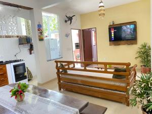 a living room with a table and a tv on the wall at Casa Próximo ao Centro in Paraty