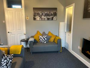 a living room with a blue couch and yellow pillows at Mustard Seed 43 Seamore Street 1/L Largs in Largs