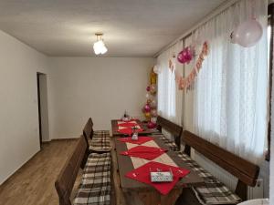 a dining room with a long table with red napkins at Къща за гости Мечта in Yagodina