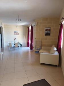 a living room with a couch and a table at Ta Wigi Farmhouse in Żebbuġ