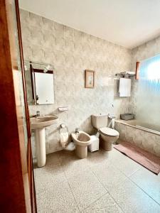 y baño con 2 aseos, lavamanos y bañera. en Casa Los Jameos en Punta de Mujeres
