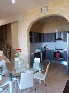 una cucina e una sala da pranzo con tavolo e sedie di Ta Wigi Farmhouse a Żebbuġ