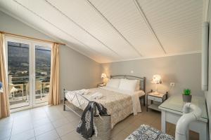 a bedroom with a bed and a balcony at Minas Apartments in Divarata