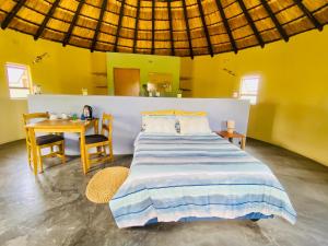 um quarto com uma cama e uma mesa com cadeiras em Izulu Eco Lodge em Sodwana Bay