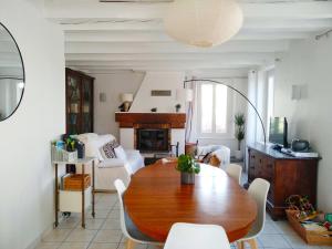 a living room with a wooden table and a couch at La Maison de Thuy - Gîte en Auvergne in Gimeaux