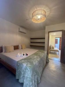 a bedroom with a large bed and a chandelier at Novo Apê Fabiano in Jericoacoara