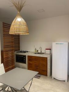 a kitchen with a white refrigerator and a table at Novo Apê Fabiano in Jericoacoara