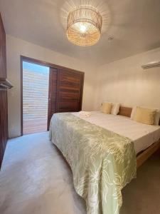 Un dormitorio con una cama grande y una lámpara de araña. en Novo Apê Fabiano en Jericoacoara