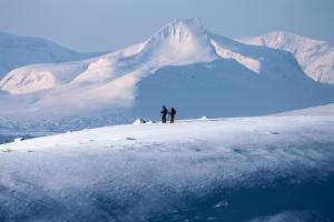 two people standing on top of a snow covered mountain at Kilpisjärven Retkeilykeskus Cottages in Kilpisjärvi